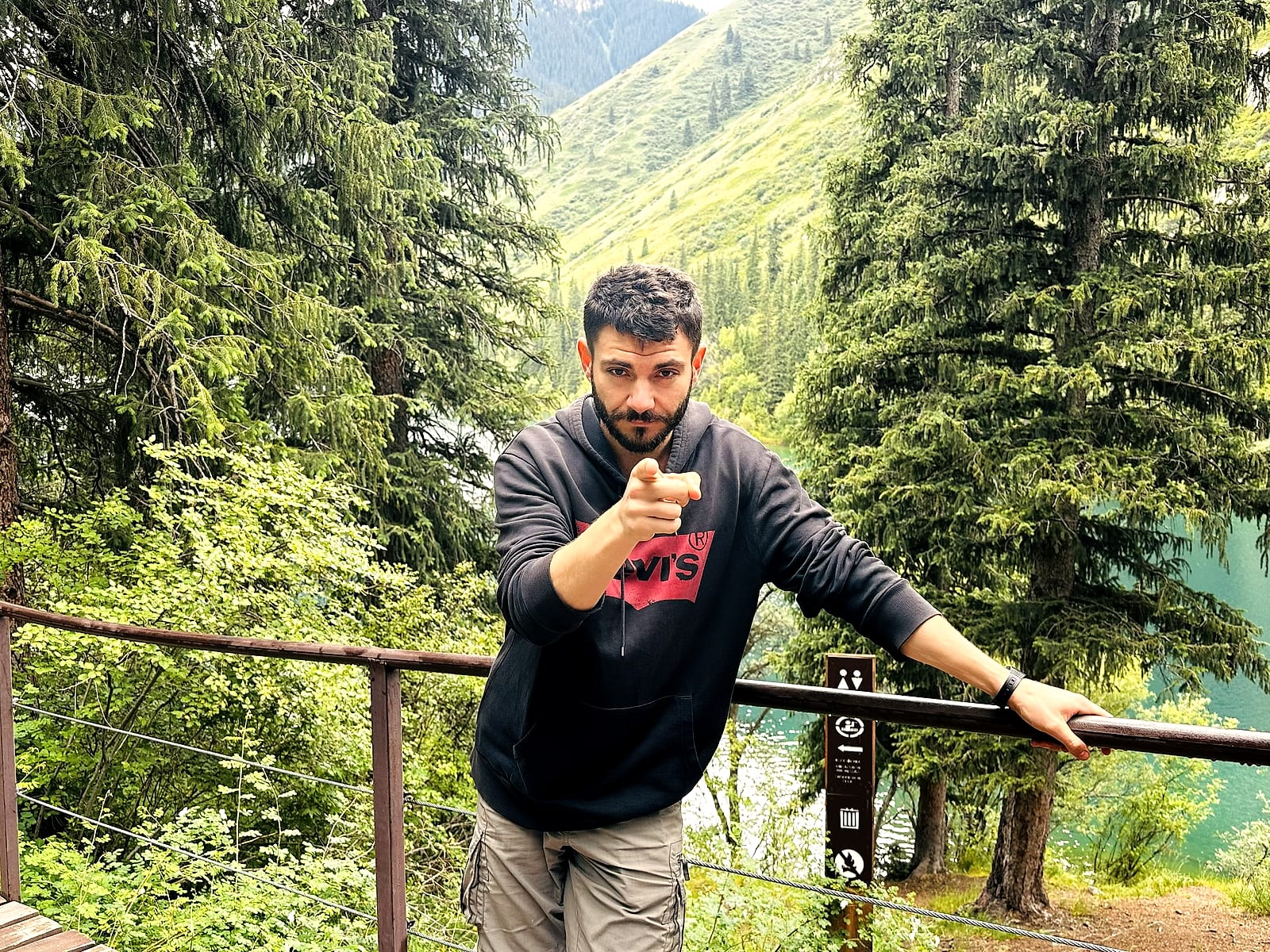 Héctor in the mountains, pointing at the camera